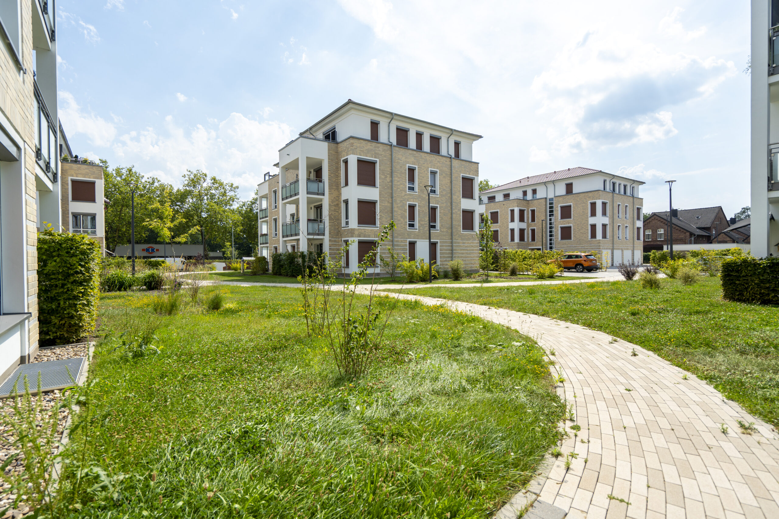 Wohngebäude mit Wiese und geschwungenem Weg