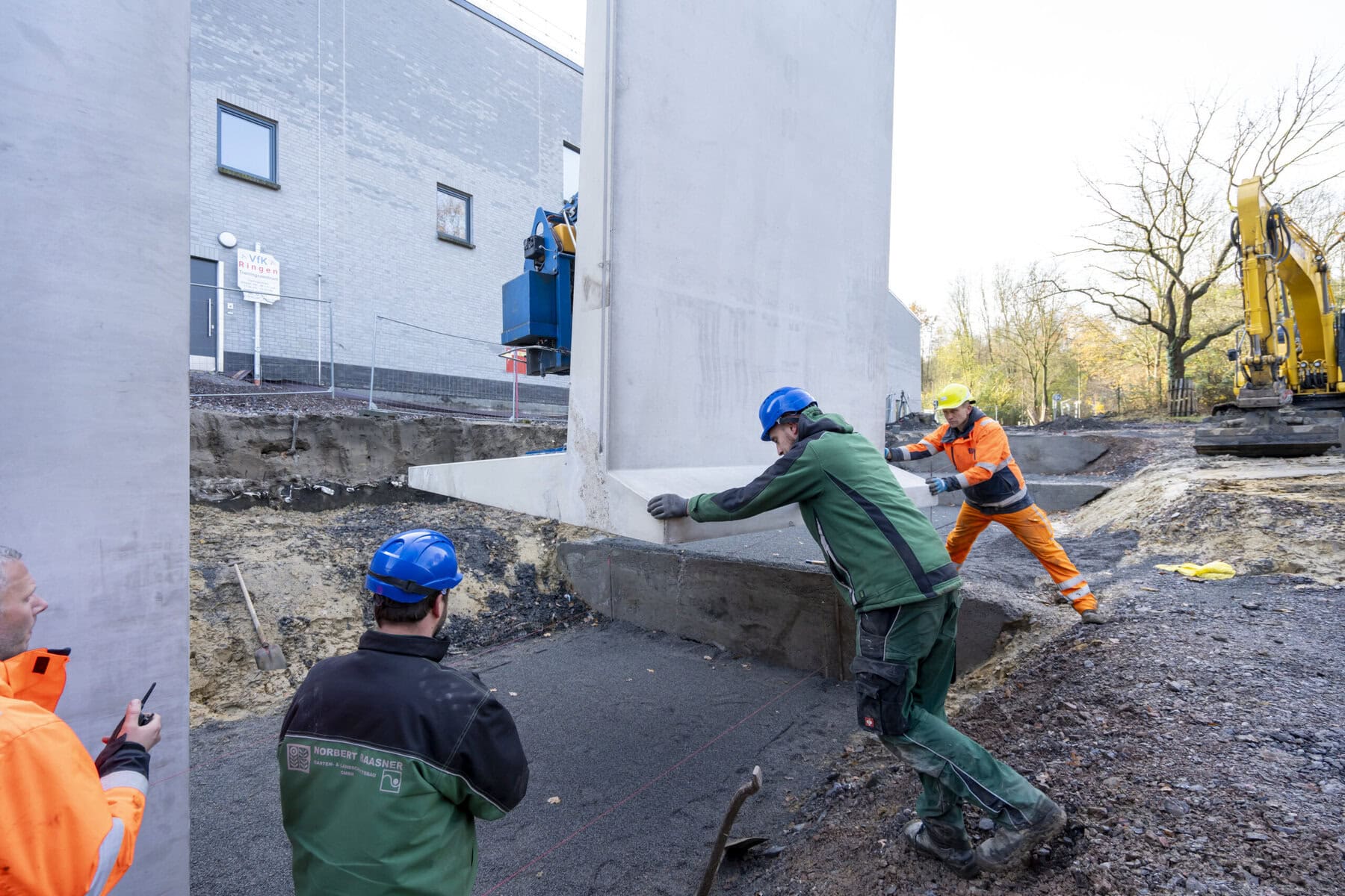 Mitarbeiter setzen ein Betonfertigteil
