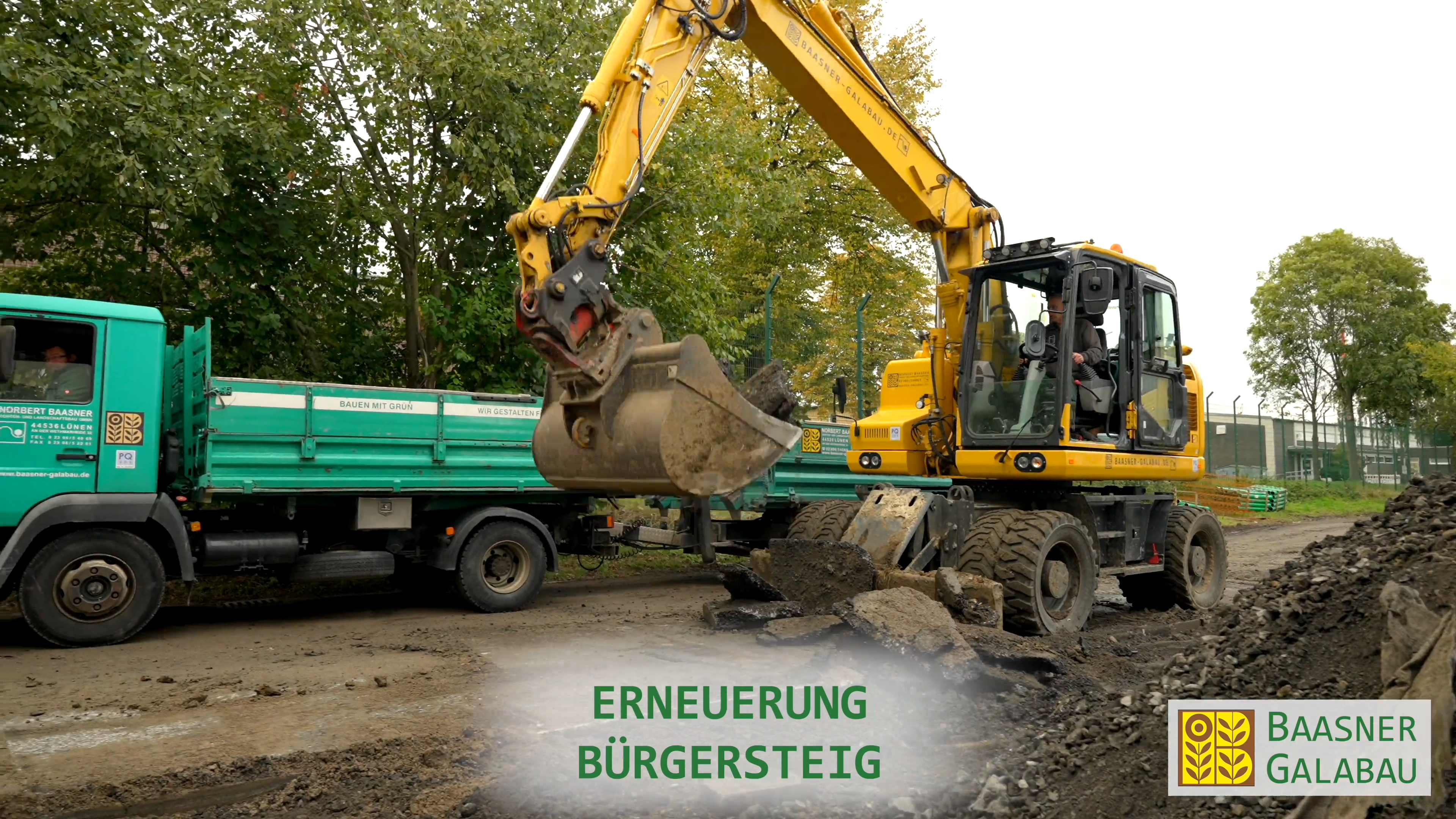 Bagger belädt einen Kipper bei der Erneuerung der Außenanlagen