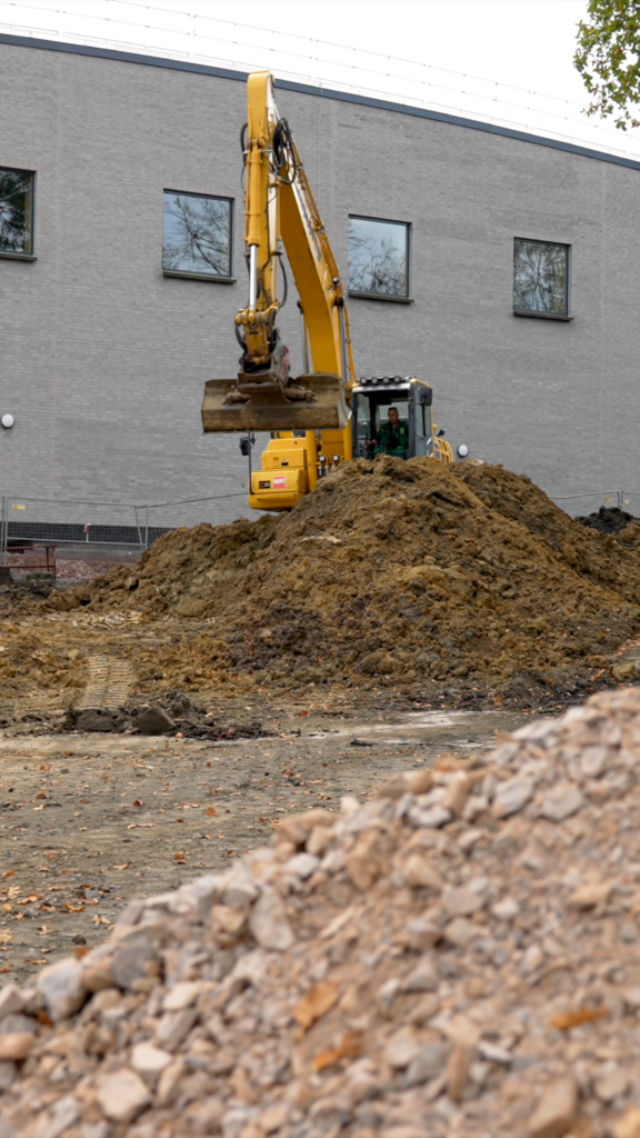 Großer Erdaushub mit Bagger auf einer Tiefbaustelle