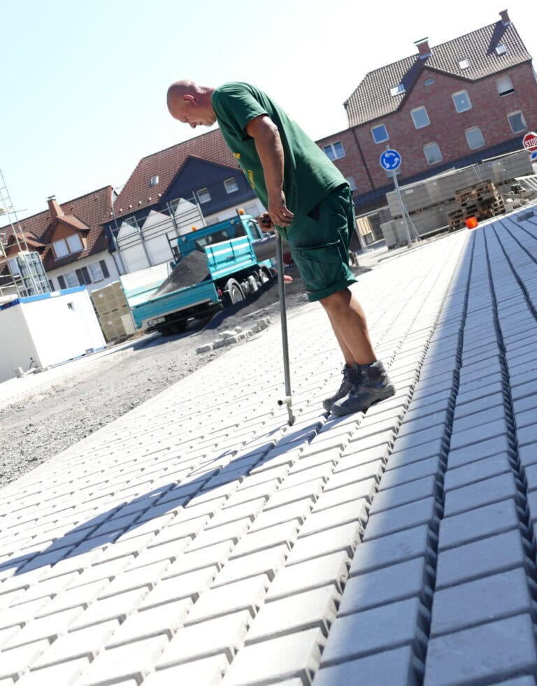 Mitarbeiter reinigt eine gepflasterte Fläche