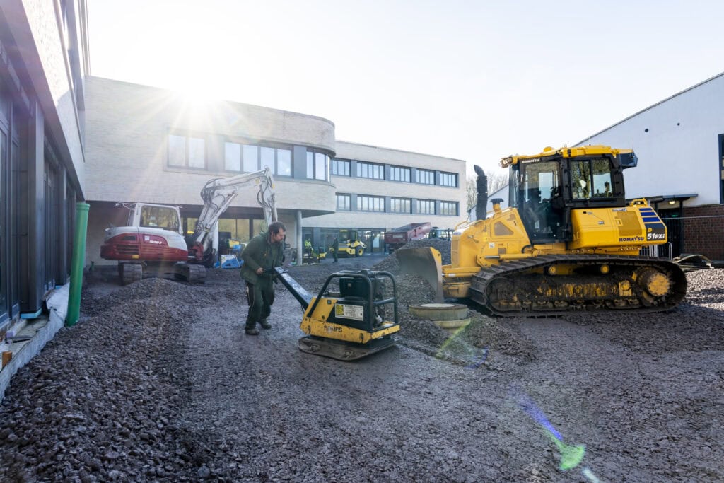 Planierraupe bei Erdarbeiten vor einem Gebäude