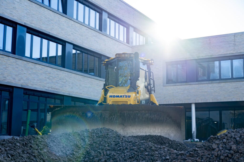Radlader vor der Glasfassade der Realschule Altlünen